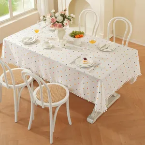 Gros plan d'une nappe en coton blanc à pois colorés avec des détails de franges