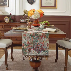 Dettaglio del runner da tavolo in jacquard floreale con accenti decorativi di nappe colorate