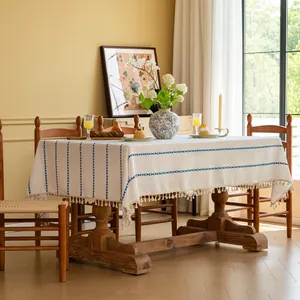 Detail van crème rechthoekig tafelkleed met blauwe strepen en fijne franje aan de rand