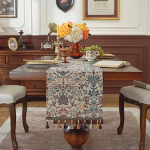 Dettaglio del runner da tavola jacquard vintage con motivi floreali e nappe eleganti