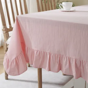 Pink tablecloth with elegant ruffle edge detail on wooden table for outdoor weddings
