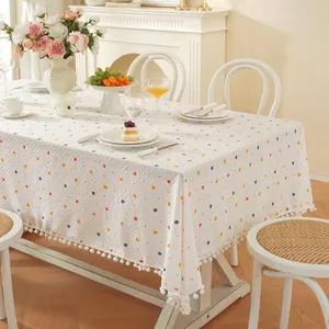 Nappe rectangulaire blanche à pois colorés avec bordure décorative à pompons blancs