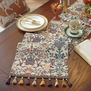 Dettaglio del runner da tavola jacquard vintage con fiori e nappe colorate