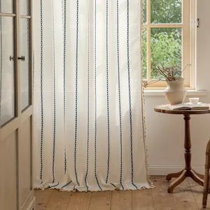 Detail of bohemian striped polyester curtain with blue embroidery and beige tassel edges