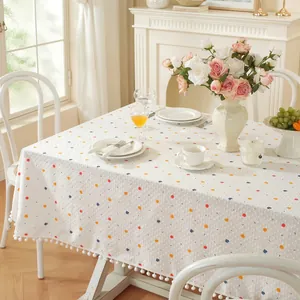 Nappe rectangulaire blanche à pois colorés et élégante bordure de franges à pompons