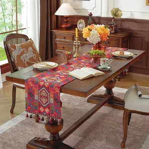 Dettaglio del runner da tavolo boho rosso con motivi etnici e nappe colorate a frange