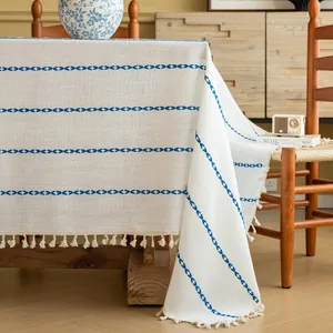 Detailweergave van beige linnen tafelkleed met blauwe strepen en luxe kwastjes