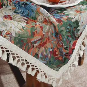 Detail van het jacquard tafelkleed met bloemenpatroon en crèmekleurige franje aan de rand