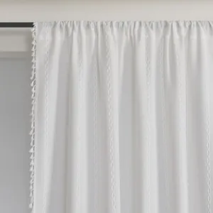 Detail of white striped curtain with diamond jacquard texture and elegant tassel fringe