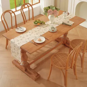Vue détaillée du chemin de table beige à fleurs avec pompons sur une surface en bois