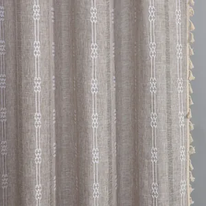 Macro detail of striped polyester curtain with geometric embroidery and fringe tassels