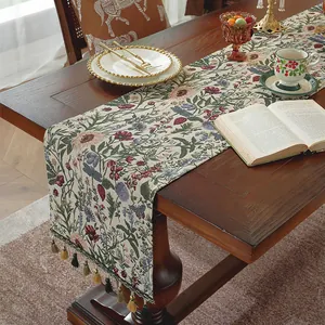 Dettaglio di runner da tavolo bohémien con nappe colorate su un tavolo in legno scuro