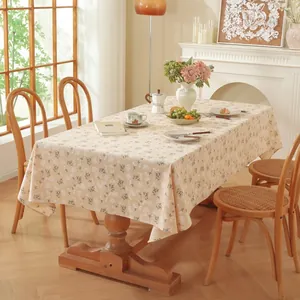 Détail d'une nappe rectangulaire fleurie à franges dans une salle à manger chaleureuse