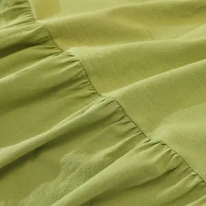 Detail shot of green cotton ruffles fabric with fine texture and stitched layers