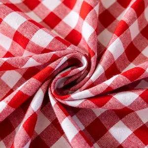 Detail of red and white gingham sofa cover fabric with elegant spiral drape and texture