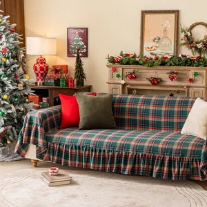 Red and green plaid Christmas sofa cover with decorative ruffled edges in a cozy room