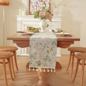 Chemin de table style crème française avec motifs floraux et pompons sur table en bois
