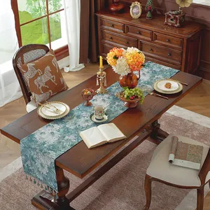 Dettaglio del runner da tavolo in jacquard con motivi floreali vintage e nappine