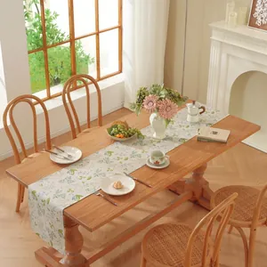 Gros plan détaillé du chemin de table crème avec motifs floraux bleus sur une table en bois