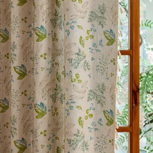Detailed close-up of pastoral leaf print fabric and handmade tassel trim on curtains