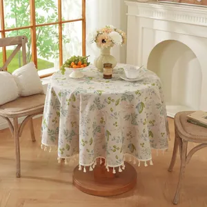 Gros plan détaillé d'une nappe ronde à motif floral avec des bordures à pompons blancs