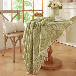 Nappe ronde verte avec motif de feuilles et pompons pour décoration de salle à manger