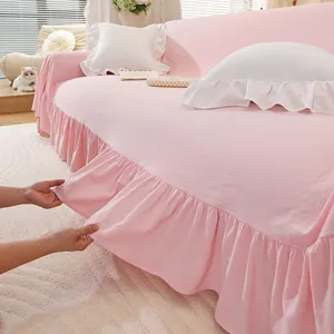 Close-up of pink cotton sofa cover showing flexible fabric and elegant ruffle hem detail