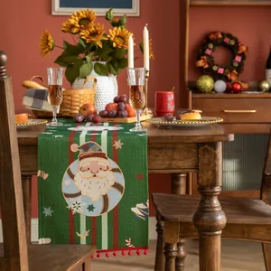Dettaglio del runner natalizio verde con motivo Babbo Natale e nappe rosse