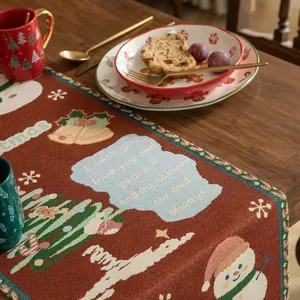 Dettaglio del runner da tavola natalizio rosso con jacquard pupazzo di neve e nappe