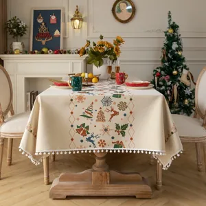 Beige Christmas tablecloth with snowflake and reindeer patterns and white pompom fringe