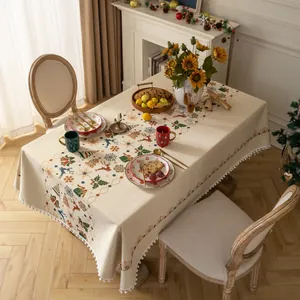 Detailed close-up of Christmas reindeer and snowflake patterns on beige fringed tablecloth