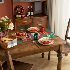 Dettaglio del runner natalizio con motivi di Babbo Natale, fiocchi di neve e nappe festive