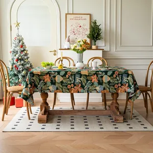 Detailed close-up of dark green Christmas tablecloth with festive floral and gift prints