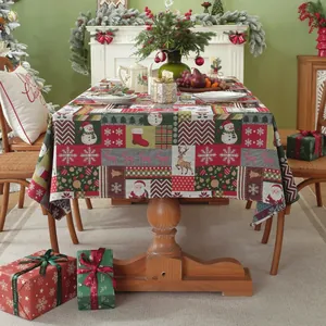 Detail of festive Christmas tablecloth featuring reindeer and Santa patterns on red fabric