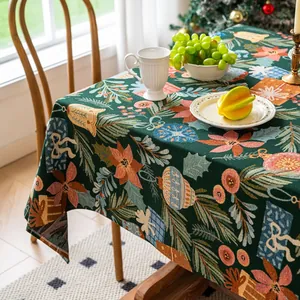 Gedetailleerde close-up van donkergroen kersttafelkleed met kerstbellen en bloempatronen
