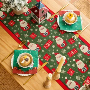 Dettaglio del runner natalizio con motivi di Babbo Natale e nappe su tavolo in legno