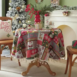 Detailed view of red Christmas round tablecloth with tassels and festive holiday motifs