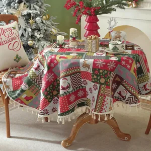 Close-up of red and green Christmas round tablecloth with tassels and reindeer patterns