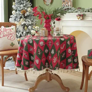 Close-up of red and green Christmas round tablecloth featuring tassel fringe and festive motifs