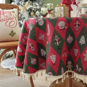 Macro view of Christmas red jacquard tablecloth featuring nutcracker patterns and tassels