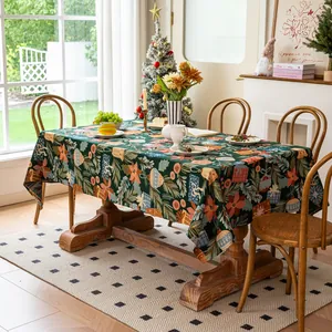 Detail of green Christmas tablecloth with red floral prints and pine needle patterns