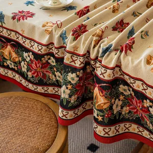 Detail of festive Christmas jacquard tablecloth with poinsettia and golden bell patterns