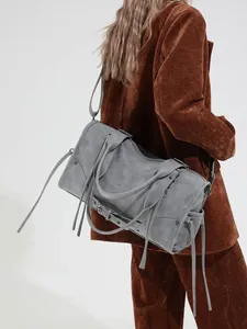 Grey oversized leather tote bag with long tassels and rivet details in biker style