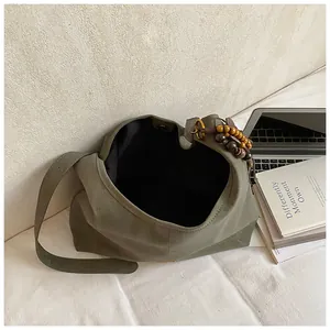 Grote minimalistische donkergroene suède draagtas met houten kralenhanger en magneetsluiting