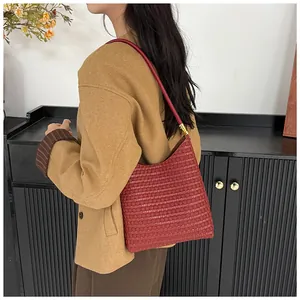 Detail of burgundy woven hobo bag with textured pattern and sleek leather shoulder strap