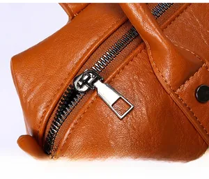 Detailaufnahme eines glatten Silber-Metallreißverschlusses an einer braunen Ledertasche