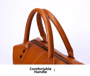 Detail der karamellbraunen Ledertasche mit dicken Doppelgriffen und hochwertigem Metallreißverschluss