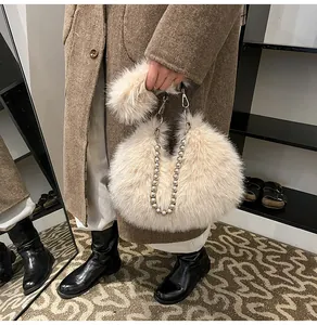 Detail of plush faux fur half-moon bag with elegant silver pearl chain and soft texture