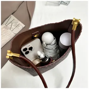 Brown woven tote bag showing large capacity storage with phone and cosmetics