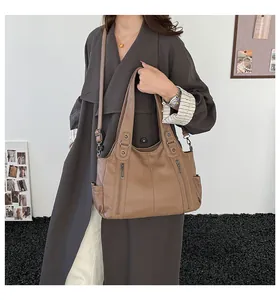 Detail view of khaki brown tote bag showing textured PU leather and metallic zippers